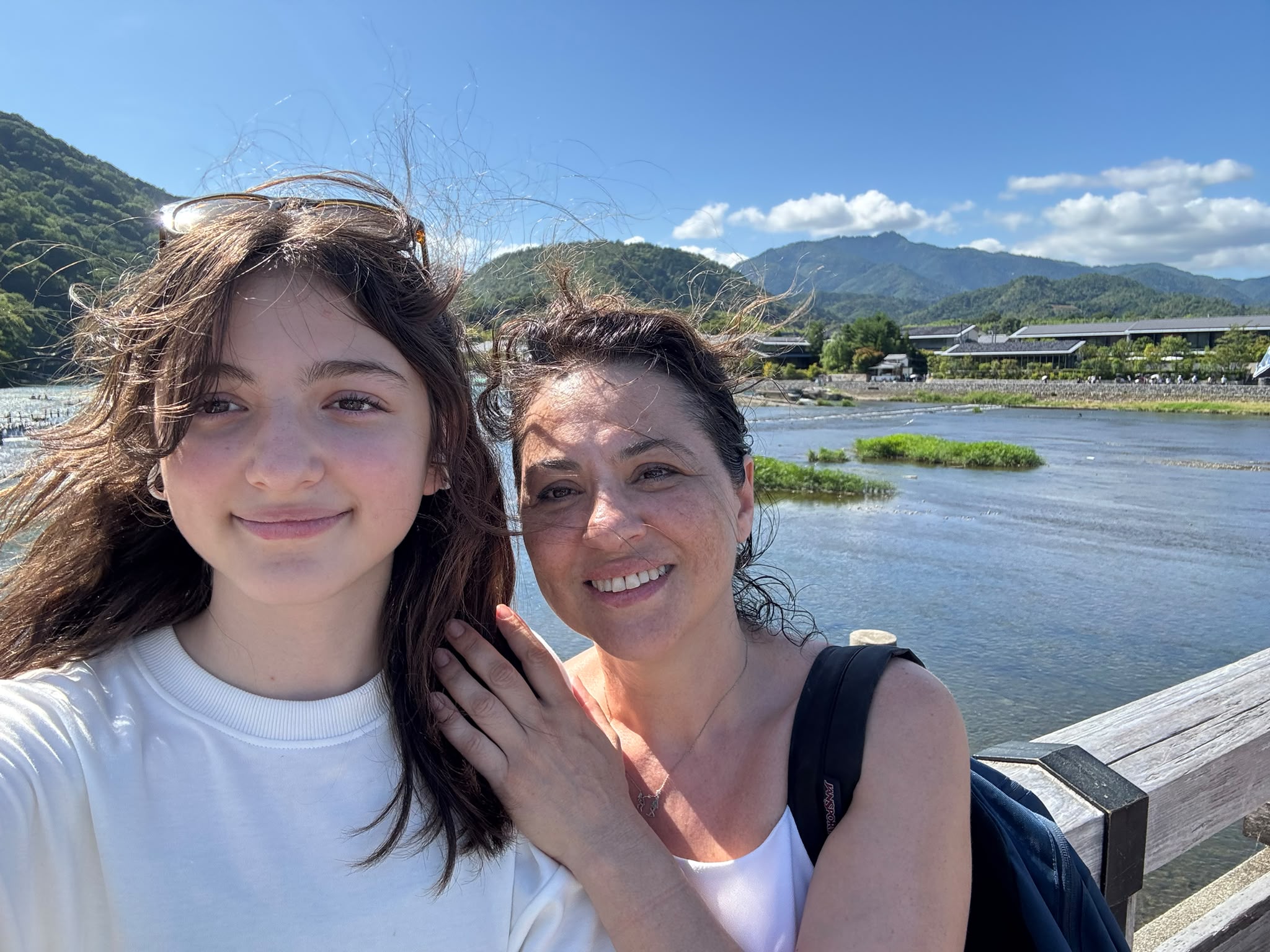 Ceren with her daughter by a river and mountains